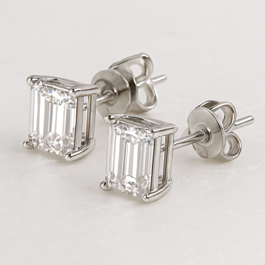 Pair of silver stud earrings featuring large, rectangular emerald-cut white cubic zirconia stones set in a four-prong sterling silver basket mount with post backs.