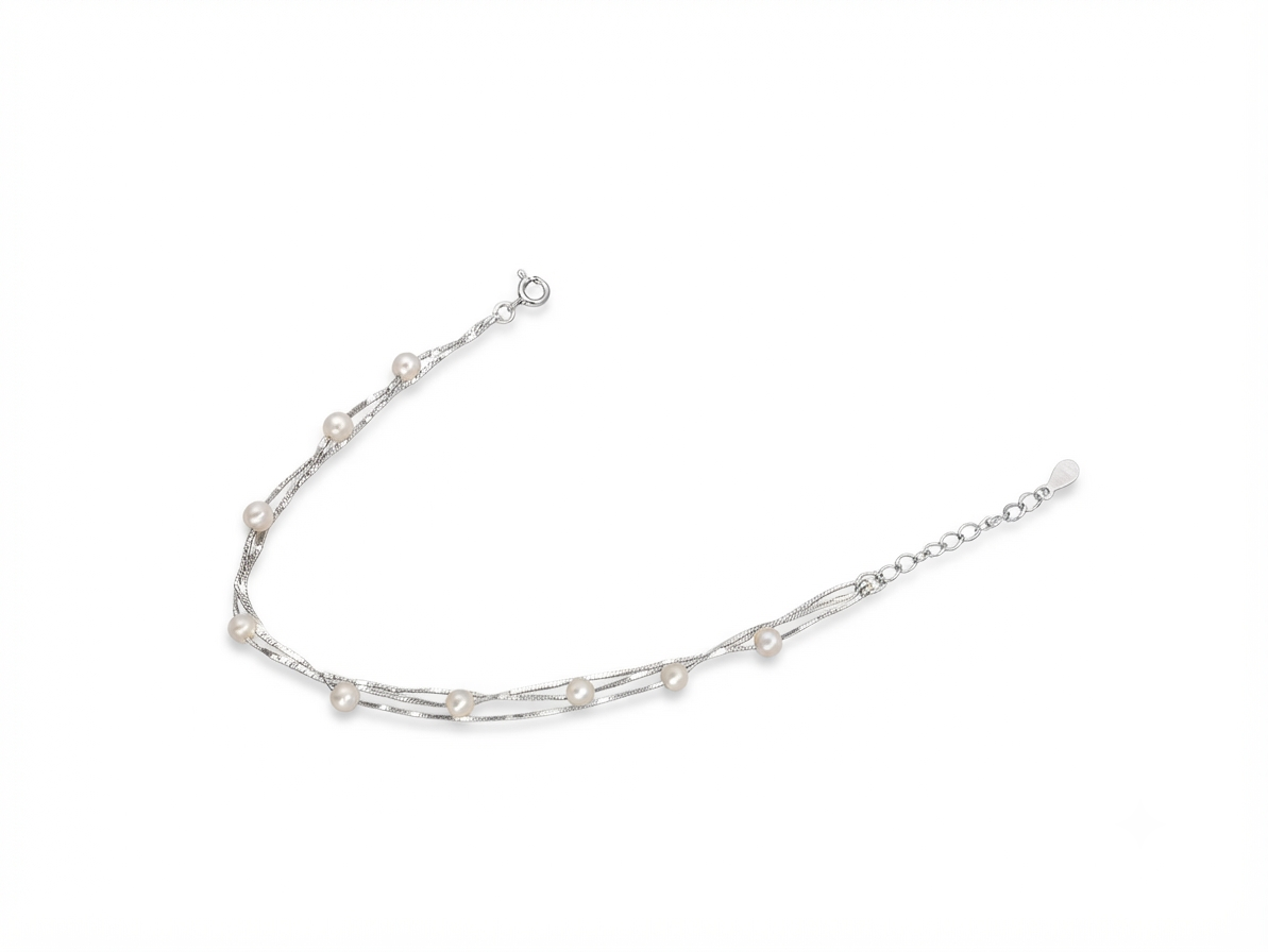 Macro close up of lustrous pearls on three interwoven 925 sterling silver chains