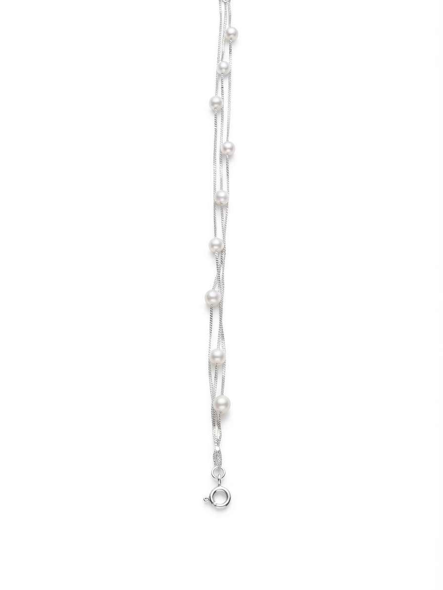 Macro close up of lustrous pearls on three interwoven 925 sterling silver chains